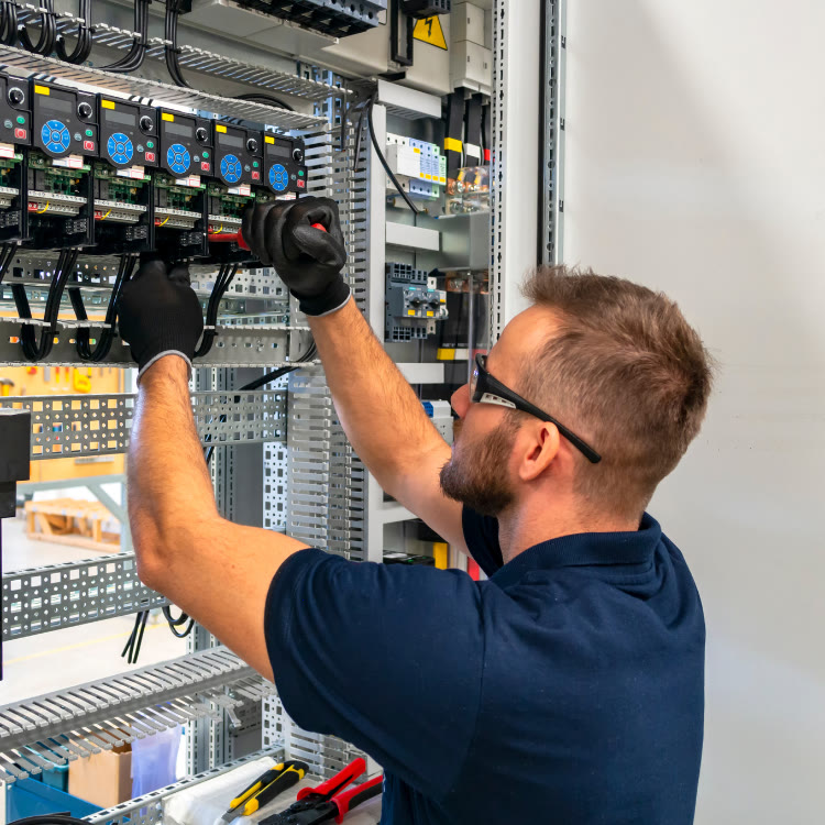 Technician commissioning an electrical control panel
